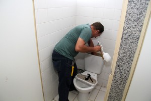 Servidor revisando a parte hidráulica para liberar banheiro interditado. (Foto: Marlon Ganassin/PMCG)